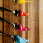 Spoons with a range of colors created using the India Tree Nature's Colors Decorating Set (natural food coloring).