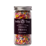 India Tree Natural Rainbow Sprinkles in a glass jar on white